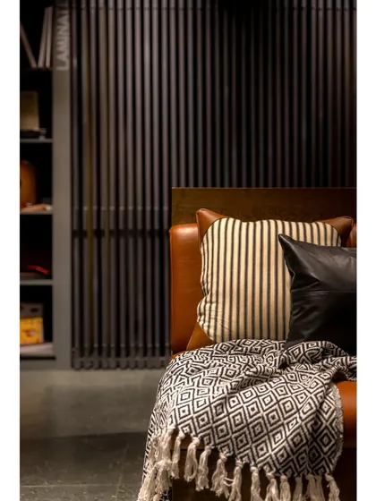 We created cozy nooks for client discussions, featuring comfortable leather seating and soft textiles. The slatted wooden screens provide a sense of privacy while maintaining the open feel of the showroom.
