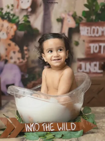A sweet and happy portrait of the baby boy in his jungle-themed milk bath.