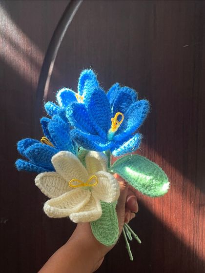 A beautiful, simple bouquet of blue and white flowers, held in hand. The colors are so serene and calming.