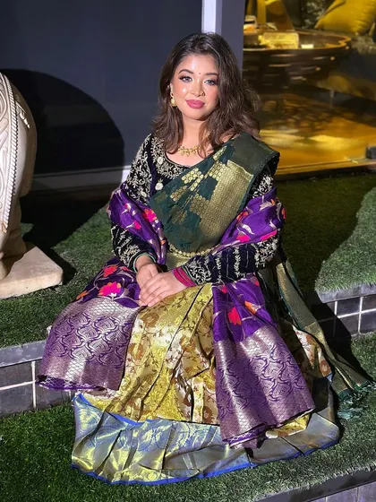 A modern take on South Indian bridal wear. This look combines a traditional half-saree drape with a contemporary velvet blouse and soft, glamorous makeup.