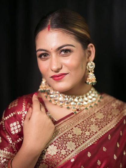 A classic beauty shot of the bride, looking confidently at the camera. This highlights her flawless makeup and stunning traditional jewelry.