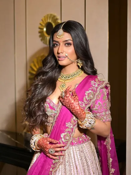 Another stunning shot of the new age bride. The makeup is designed to complement the vibrant pink of her outfit, creating a look that is both bold and beautiful.