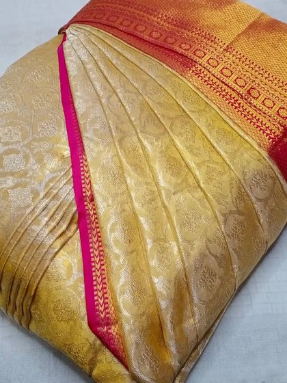 This cream and gold saree with a pink border is a classic combination. My pre-pleating service makes wearing such traditional sarees completely effortless.