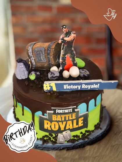 Victory Royale! This Fortnite-themed cake is perfect for a battle royale fan, featuring a loot chest, a character, and the iconic game logo.