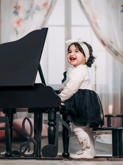 A daughter is one of the greatest gifts. This happy girl, dressed in black and white, loves playing the piano in our studio.