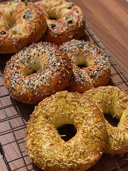 A close-up of my assorted bagels, including everything, jalapeño cheese, and pesto cheese flavors, fresh from the oven.
