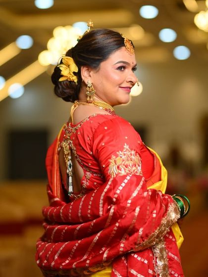 This bride exudes royal beauty. Her look features a classic hairstyle with yellow flowers and makeup that highlights her elegant features.