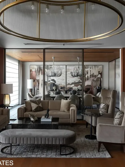 The formal living room in Residence 338 uses a monochrome palette of stone, veneer, and gray tones, punctuated by curated artwork to create a unified and tranquil atmosphere.