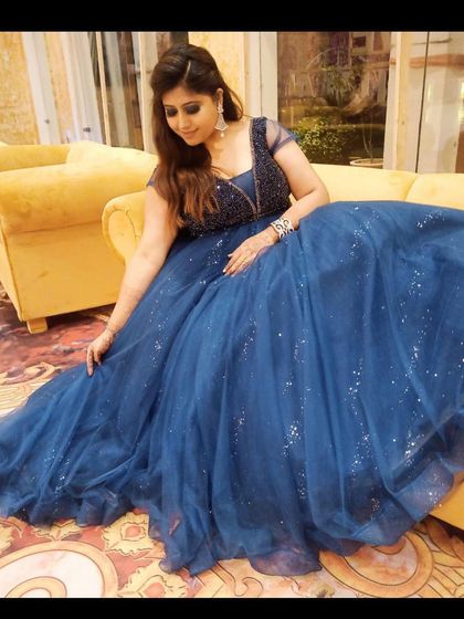 This deep blue ball gown has a sparkling tulle skirt and an embellished bodice. It's a classic, elegant choice for a formal reception or black-tie event.