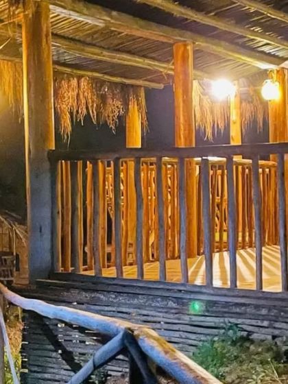 The warm lighting of the treehouse balcony creates a perfect ambiance for a peaceful evening.