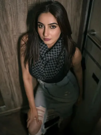 A moody, high-angle shot taken in a confined space, likely a vanity van. The lighting and composition create an intense and intimate portrait, showcasing a more edgy, urban style.