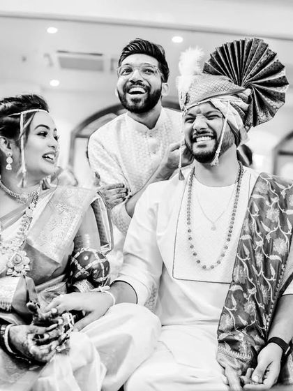 A joyful, candid moment during a Maharashtrian wedding ceremony. This black and white photo captures genuine laughter and interaction.