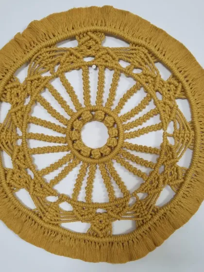 This large, mustard-yellow macrame mandala is a true statement piece. The circular design, full of intricate knots and patterns, brings a sense of harmony and focus to any wall.