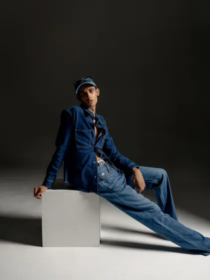 A full-body shot featuring a denim-on-denim look for Calvin Klein. The styling is classic and clean, while the pose is relaxed and confident, perfectly capturing the brand's American heritage.
