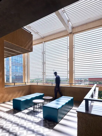 At the Mahindra office in Chakan, operable louvres on a breakout terrace provide shade and modulate airflow, a key feature of our climate-responsive design approach. This space allows employees to connect with the outdoors without compromising comfort.