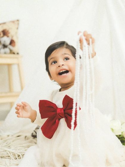 This cutie is having so much fun playing with a string of pearls. Sometimes the simplest things bring out the biggest smiles.