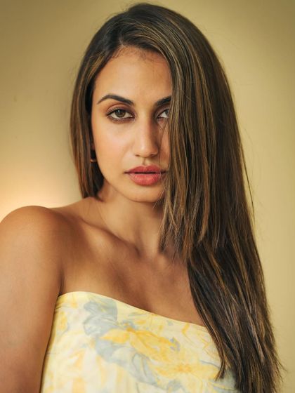 A strong and simple beauty headshot. The lighting is clean and flattering, highlighting the model's features and the sleekness of her hair. Her expression is confident and direct.