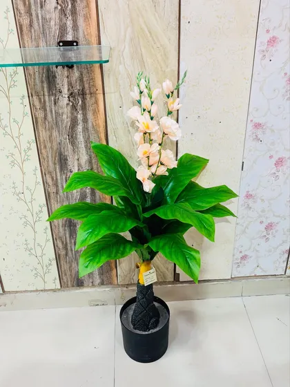 An elegant artificial plant with lush green leaves and delicate light pink flowers, adding a soft touch of color.