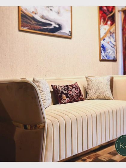 This channel-tufted sofa in a soft beige fabric exudes understated elegance. The metallic accents on the arms add a subtle touch of glamour, making it a versatile piece for both modern and transitional interiors.