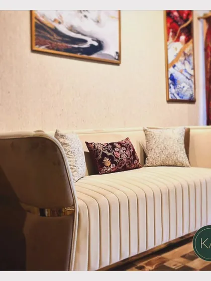 This channel-tufted sofa in a soft beige fabric exudes understated elegance. The metallic accents on the arms add a subtle touch of glamour, making it a versatile piece for both modern and transitional interiors.