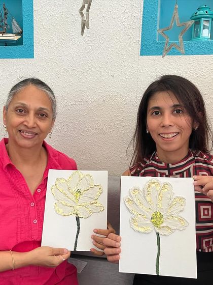 Two participants holding up their finished floral texture paintings. They both started as complete beginners.