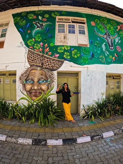 In the heart of Fort Kochi, I painted 'The Silver Eyes of Kochi' to honor the spirit of the local fisherwomen. My art is about connecting with people and their stories. This mural, on the wall of the Kashi Art Cafe, became a part of the street and the community's daily life.