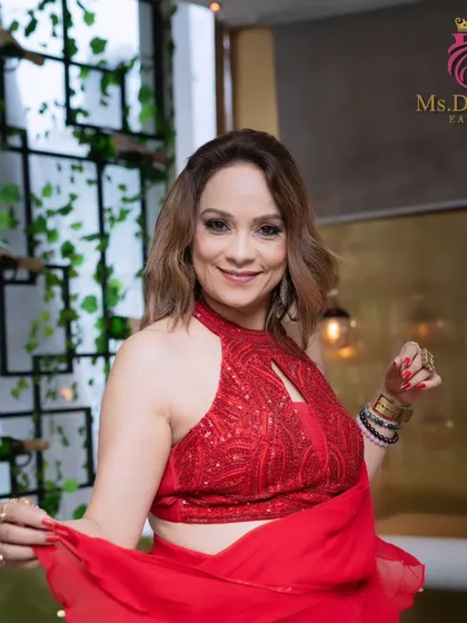 A full shot of the model from the photoshoot, looking radiant and confident in her red ensemble.