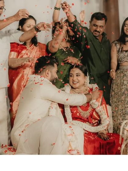 A joyous moment as the couple is showered with flower petals by their family, a blessing for their new life together.