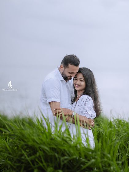 A warm hug from behind, framed by the vibrant green foliage. This pose is intimate and shows a sense of protection and love.
