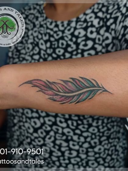 A colorful feather tattoo done by our artist, Maxy. The mix of pink, green, and white gives this classic design a vibrant twist.