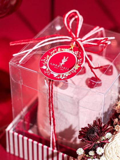 A beautifully packaged mini cake for Valentine's Day, tied with red and white twine. A sweet gesture of love.