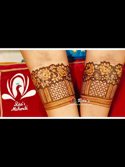 A close-up of the arm bands for an engagement mehendi, featuring intricate floral and net patterns.