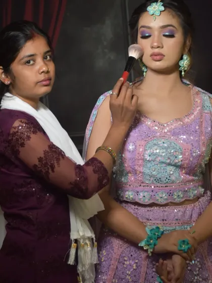 In this session, a student creates a vibrant sangeet or mehndi look. She is applying makeup to a model wearing a beautiful pastel lehenga, learning how to match makeup tones with colorful outfits.