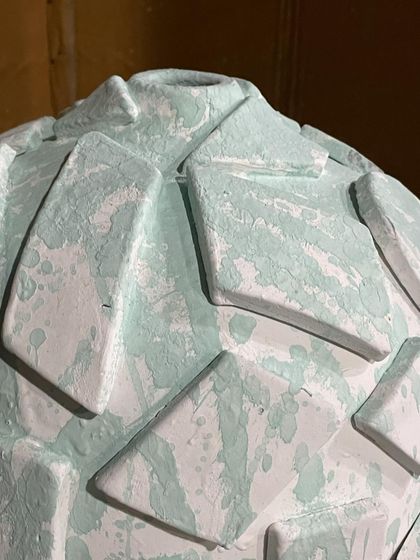 A close-up of the applied glaze on a textured Moon Jar. You can see the raw, chalky quality of the unfired glaze, which will melt into a glassy surface in the heat.