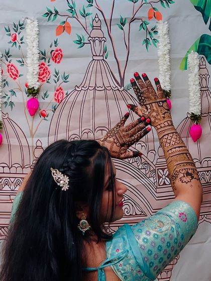 A bride posing with her intricate mehendi, showing how the design becomes a beautiful accessory to her overall look.