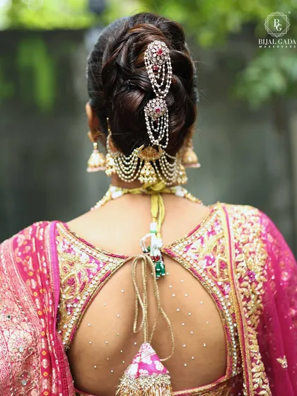 An elegant braided bun adorned with traditional Maharashtrian hair accessories. This hairstyle is perfect for keeping the hair neatly in place while adding a touch of royal charm from the back.