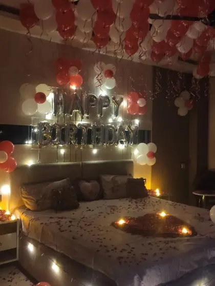 A view of the surprise birthday room decor from another angle, showing the warm ambiance created by the fairy lights and candles.