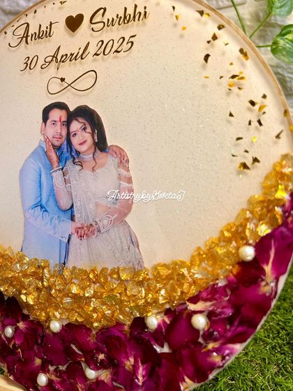 A close-up view of the personalized names and date on the floral preservation frame. The gold lettering adds a touch of elegance to the heartfelt keepsake.