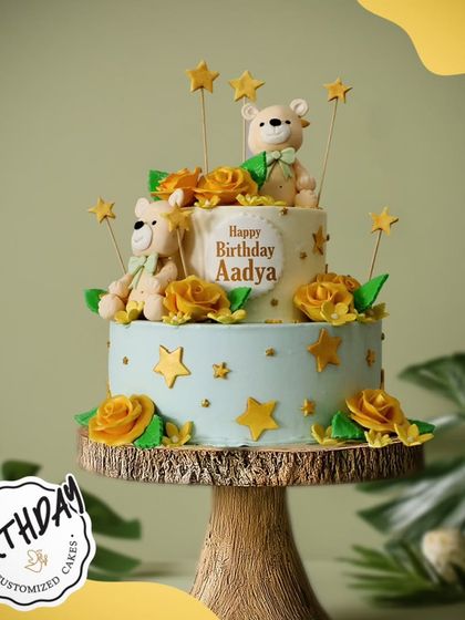 A charming two-tier cake with teddy bears, yellow roses, and stars. This sweet and elegant design is perfect for a special birthday celebration.