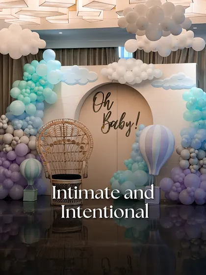 A whimsical 'Oh Baby!' shower designed with intention and love. The theme was brought to life with a soft balloon installation resembling clouds, a classic peacock chair for the mother-to-be, and hot air balloon details for a touch of playful charm.