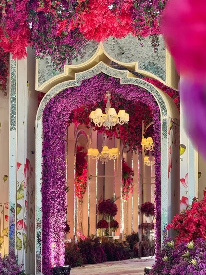 A detail of the floral archway, where a tunnel of purple flowers is framed by a mirrored arch, creating a beautiful play of light, color, and reflection.