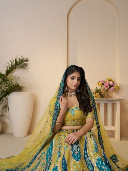 A client looking beautiful in a yellow and teal printed lehenga, a vibrant choice for a sangeet or mehndi function.
