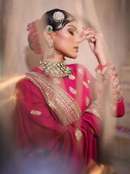 A dreamy, artistic shot of the pink lehenga. The soft focus and pose create a romantic and ethereal mood.
