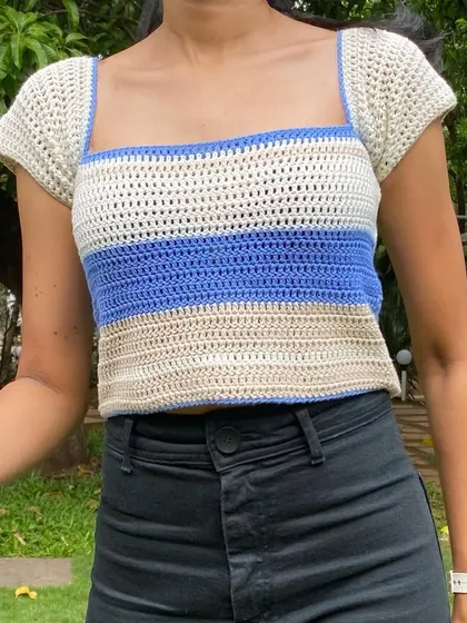 A detailed look at the stitch work on our cap sleeve top. The combination of beige, blue, and cream creates a soft, coastal-inspired color palette.