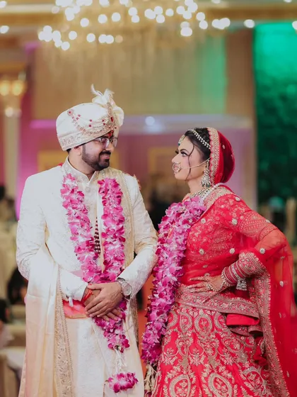 A classic wedding portrait of the couple, looking at each other with love and admiration. The vibrant colors of their outfits and the decor come alive in this shot.