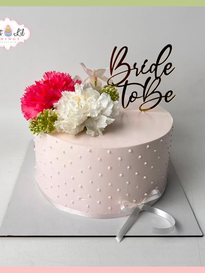A blushing "Bride to be" cake. This simple yet elegant pink cake is decorated with a Swiss dot pattern and topped with fresh carnations.