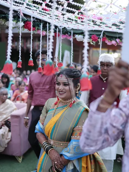 The bride walking under a canopy of flowers, looking serene and beautiful.