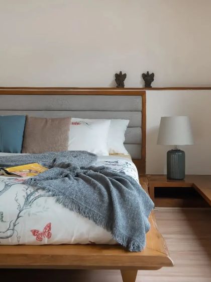 A beautiful live-edge bed with a stunning grey upholstered headboard, perfect for a modern bedroom. The extended headboard doubles as a sleek, integrated nightstand.