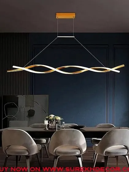 This modern curled LED chandelier in a golden finish is perfect for hanging over a dining table. Its fluid, sculptural form adds an artistic element to the room, as seen in this dark, moody dining space with plush grey chairs.