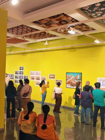 Visitors explore the exhibition against the gallery's vibrant yellow and pink walls. The bright, neo-pop aesthetic of the show's design reflects the playful and theatrical nature of Cop Shiva's photography.